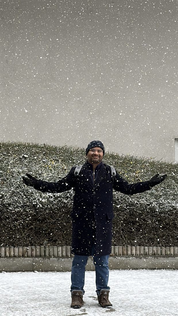 Khurram with arms wide open in falling snow